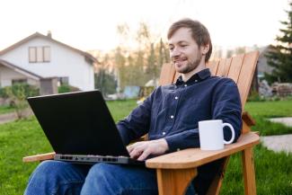 man with laptop in backyard